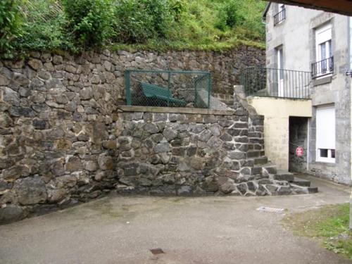 a stone wall with a bench on top of it at LES CAPUCINES 1 in Le Mont-Dore