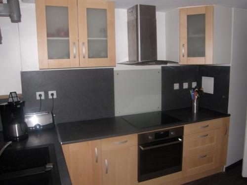 a kitchen with wooden cabinets and a black counter top at LES CAPUCINES 1 in Le Mont-Dore