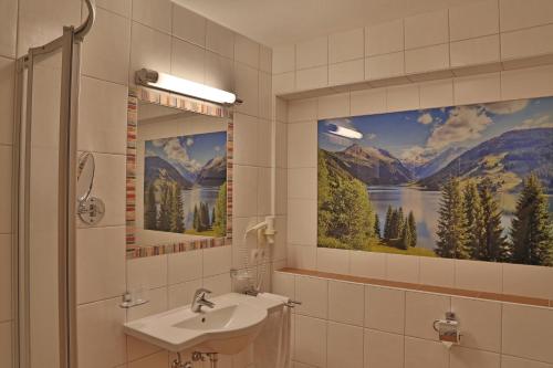 uma casa de banho com um lavatório e uma pintura na parede em Chalet Lena em Gerlos