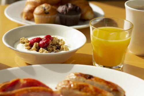 a table with plates of breakfast food and a glass of orange juice at Holiday Inn Express Southampton - M27, J7 by IHG in Southampton