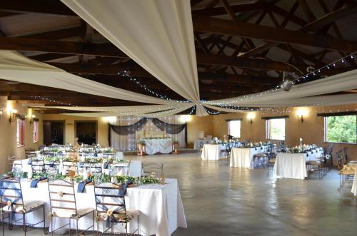 a large banquet hall with white tables and chairs at Tava Lingwe Game Lodge & Wedding Venue in Parys