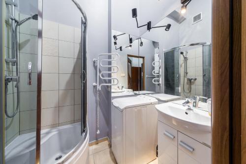 a bathroom with two sinks and a shower at Mrówka in Kraków