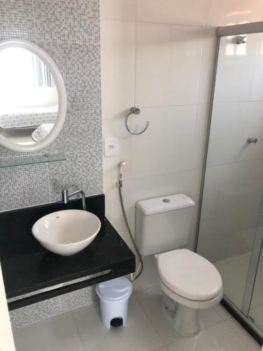 ein Badezimmer mit Toilette, Waschbecken und Spiegel in der Unterkunft Casa Conchas - Aluguel por Temporada Barra de São Miguel in Barra de São Miguel