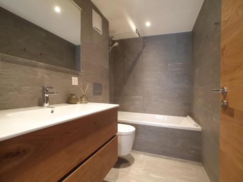 uma casa de banho com um lavatório, um WC e uma banheira em Britannia em Saas-Fee