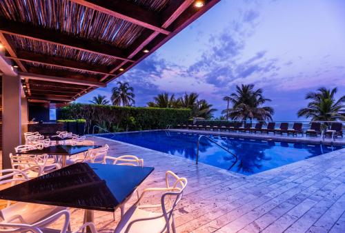 a resort with a swimming pool and tables and chairs at Holiday Inn Cartagena Morros, an IHG Hotel in Cartagena de Indias