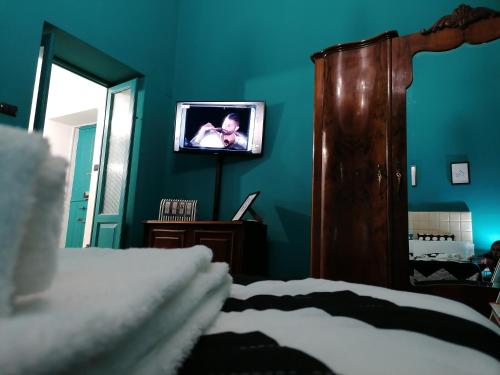 ターラントにあるCasaCasetta Suite Appartamento Indipendenteのベッドと壁掛けテレビのある寝室