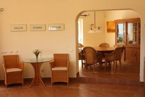 a dining room and kitchen with a table and chairs at Villa with beautiful sea views, pool & spacious gardens & great for remote work in Ferragudo