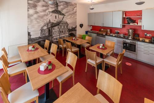 a restaurant with tables and chairs and a kitchen at Hotel am Brauerei-Dreieck in Bamberg