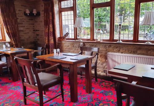 a dining room with tables and chairs and windows at Stow Lodge Hotel in Stow on the Wold