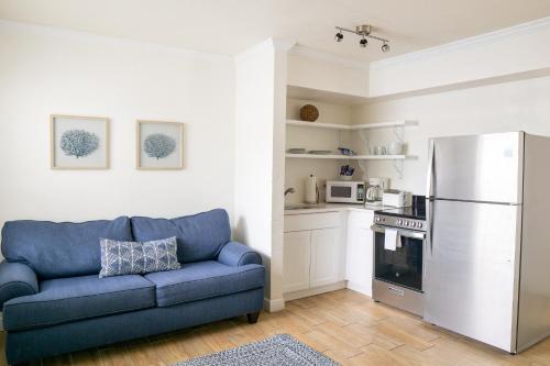 a living room with a blue couch and a kitchen at Molloy Gulf Motel & Cottages in St. Pete Beach