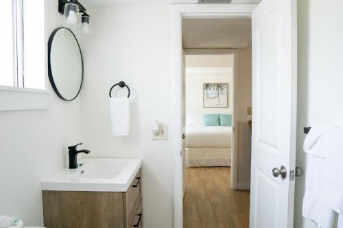 een witte badkamer met een wastafel en een spiegel bij Molloy Gulf Motel & Cottages in St Pete Beach