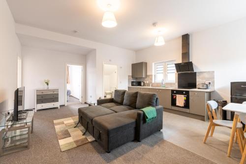 a living room with a couch and a kitchen at The Eldern - Spacious, Netflix, free Parking, close to A1 in Peterborough