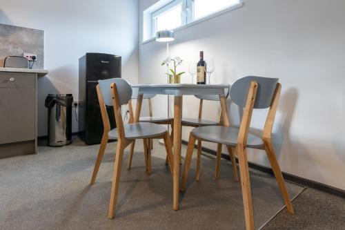a dining room table with three chairs and a bottle of wine at The Eldern - Spacious, Netflix, free Parking, close to A1 in Peterborough
