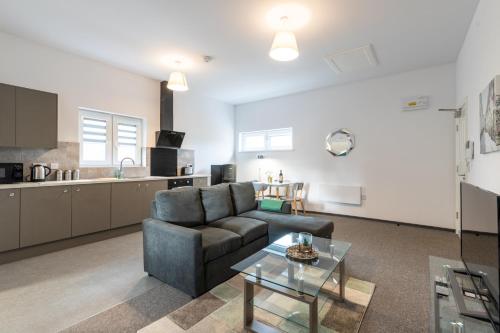 a living room with a couch and a table at The Eldern - Spacious, Netflix, free Parking, close to A1 in Peterborough