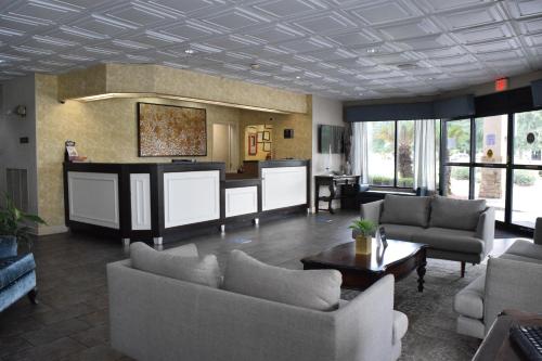 a living room with couches and a table at Ramada by Wyndham Savannah Gateway in Savannah