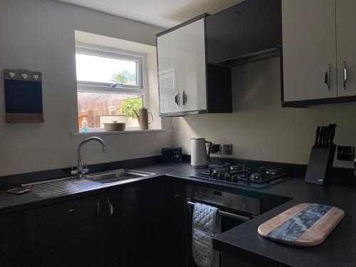 uma cozinha com um lavatório, um fogão e uma janela em Bondgate Holiday Cottage em Durham