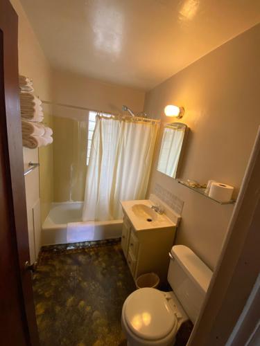 a bathroom with a toilet and a sink and a tub at Rainbow Motel in Thermopolis