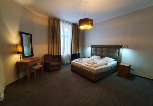 1 dormitorio con cama, escritorio y silla en Kamienica Bankowa Residence, en Poznan