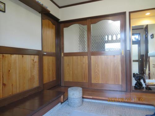 Guest House Miyazu Kaien - Vacation STAY 99191 في ميازو: غرفة ذات أبواب خشبية ومقعد