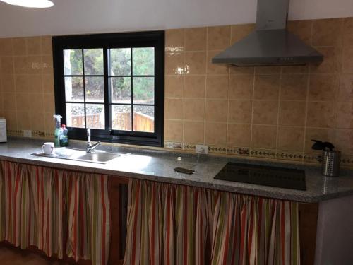 a kitchen counter with a sink and a window at La Campana de Arriba in La Guancha