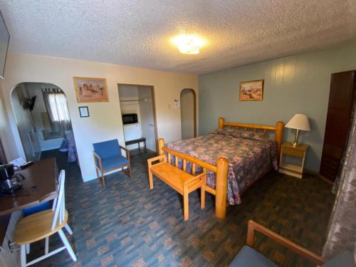 Rainbow Motel في ثرموبوليس: غرفة نوم بسرير وطاولة وكراسي