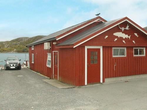 un edificio rojo con un coche aparcado delante de él en 6 person holiday home in Oksvoll, en Oksvoll