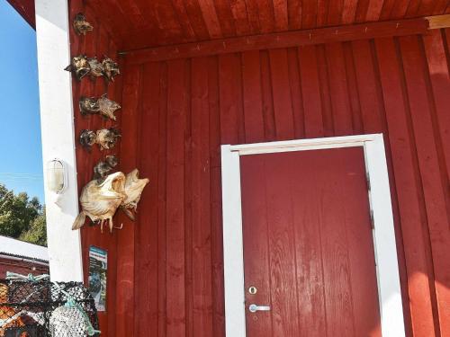 un edificio rojo con una puerta roja con un animal muerto en él en 6 person holiday home in Oksvoll, en Oksvoll