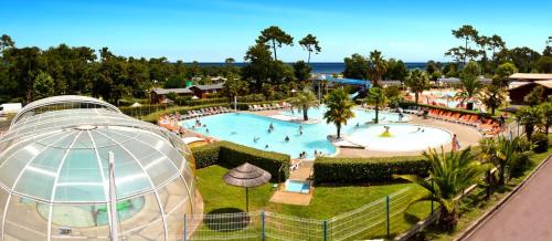une vue d'une piscine dans un complexe hôtelier dans l'établissement Mobil home au calme au Cap-Ferret - Camping les viviers 