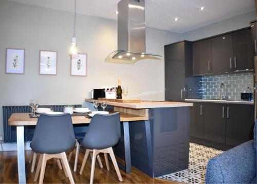 a kitchen with a table and some blue chairs at 5a Bank Street in Keswick