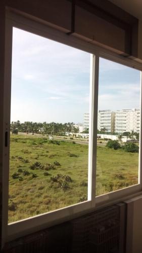 a window with a view of a field of grass at Puerta diamante acapulco in Acapulco