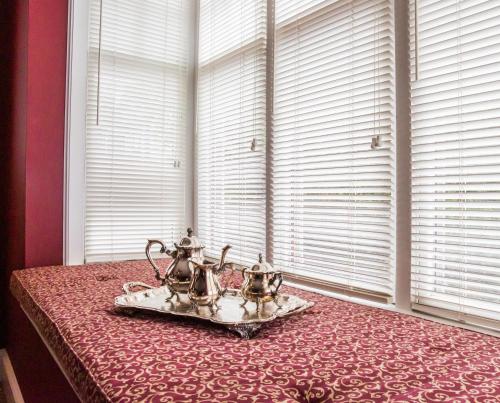 a tray of tea pots sitting on a bed next to a window at Almondy Inn Bed & Breakfast in Newport