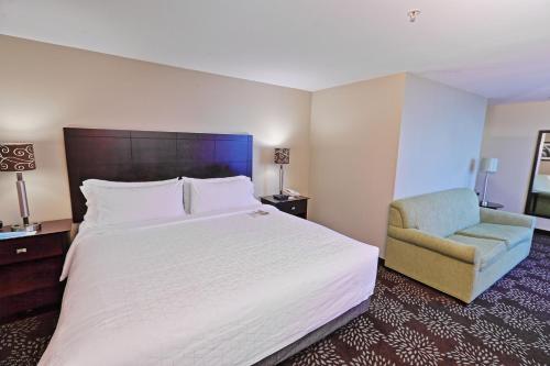 een hotelkamer met een groot bed en een stoel bij Holiday Inn Express Pittsburgh West - Greentree, an IHG Hotel in Pittsburgh