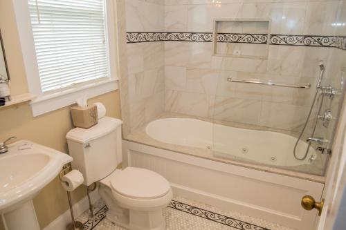 a bathroom with a toilet and a tub and a sink at Almondy Inn Bed & Breakfast in Newport