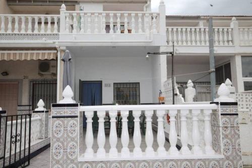 balcón blanco de una casa con barandilla blanca en Bungalov u Růžové laguny, en Torrevieja