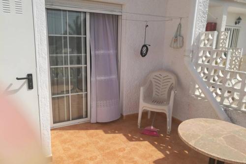 um quarto com uma escada, uma cadeira e uma mesa em Bungalov u Růžové laguny em Torrevieja