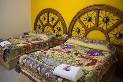 2 bedden in een kamer met glas-in-loodramen bij Hotel Morelos Colima in Colima