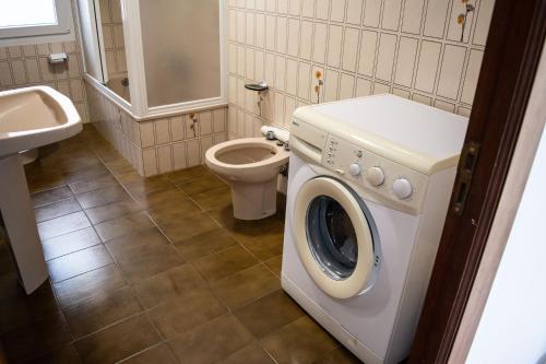 een badkamer met wasmachine en toilet bij Apartamento PLAYA ESTEIRO in Muros