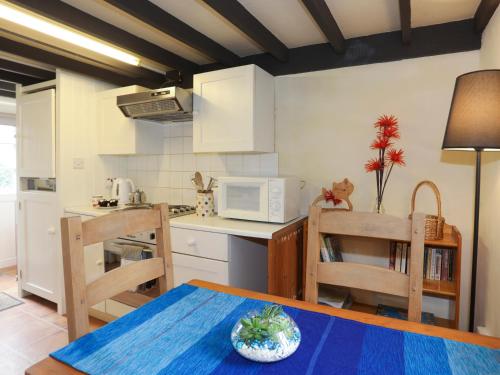 a kitchen with a table and chairs and a microwave at Glan Aber in Amlwch
