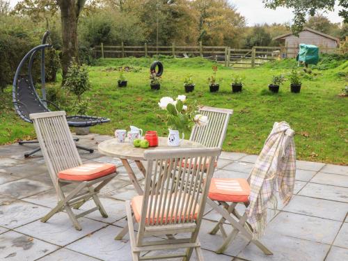 a table with two chairs and a table with flowers at Glan Aber in Amlwch