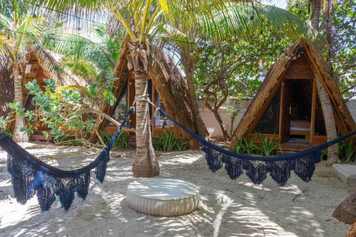 a hammock in front of a house with palm trees at Selina Poc Na Isla Mujeres in Isla Mujeres