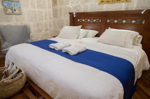 a bedroom with a large bed with two towels on it at Hotel Casona Solar in Arequipa