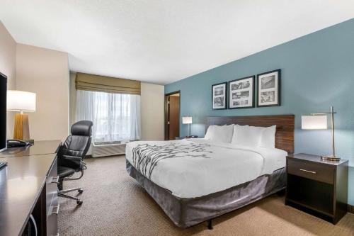 a hotel room with a bed and a desk and chair at Sleep Inn & Suites Ames near ISU Campus in Ames