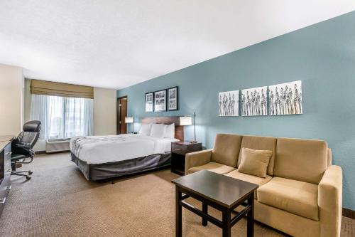 um quarto de hotel com uma cama e um sofá em Sleep Inn & Suites Ames near ISU Campus em Ames