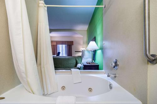 a bathroom with a tub and a living room at Quality Inn & Suites near I-80 and I-294 in Harvey