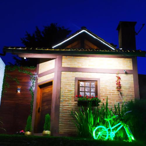 a house with a green bike in front of it at Canquerini Chalés in Monte Verde