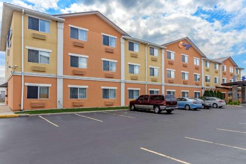 un grand bâtiment avec des voitures garées dans un parking dans l'établissement Comfort Inn Gurnee near Six Flags, à Gurnee