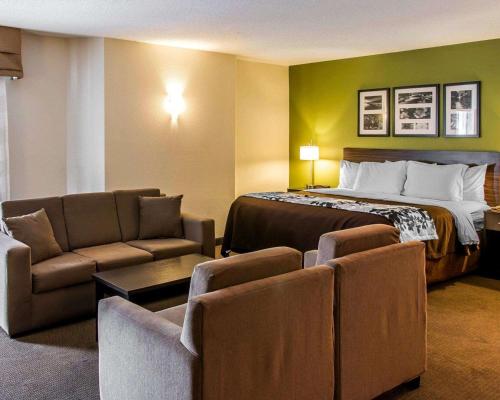 Habitación de hotel con cama, sofá y sillas en Sleep Inn Midland en Midland