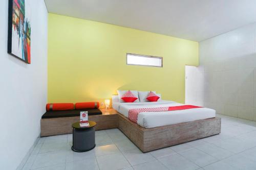 a bedroom with a bed and a table in it at Cityzen Renon Hotel in Denpasar