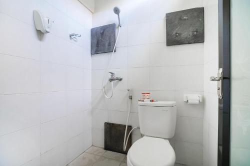 a bathroom with a toilet and a shower at Cityzen Renon Hotel in Denpasar