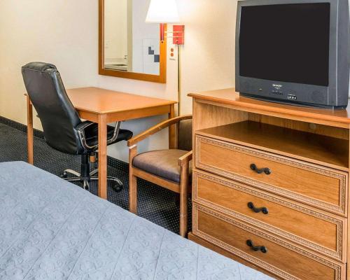 a hotel room with a bed and a tv on a dresser at Quality Inn Kalamazoo near Wings Stadium in Kalamazoo